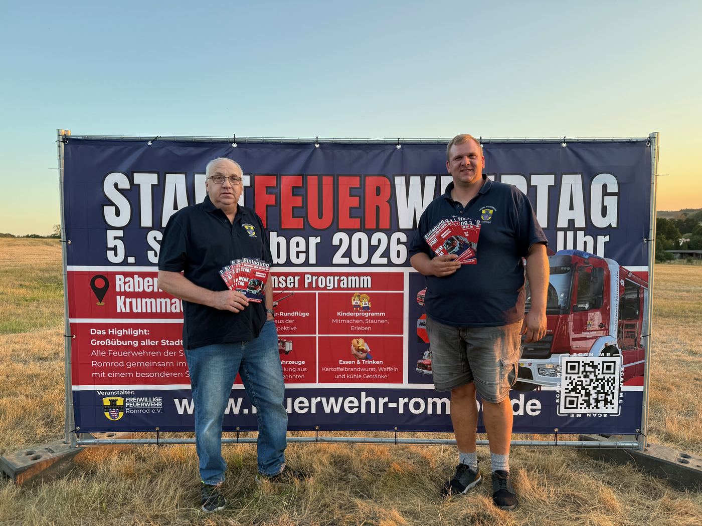 Reinhold Weitzel und Manuel Gemmer vor dem Werbebanner zum Stadtfeuerwehrtag